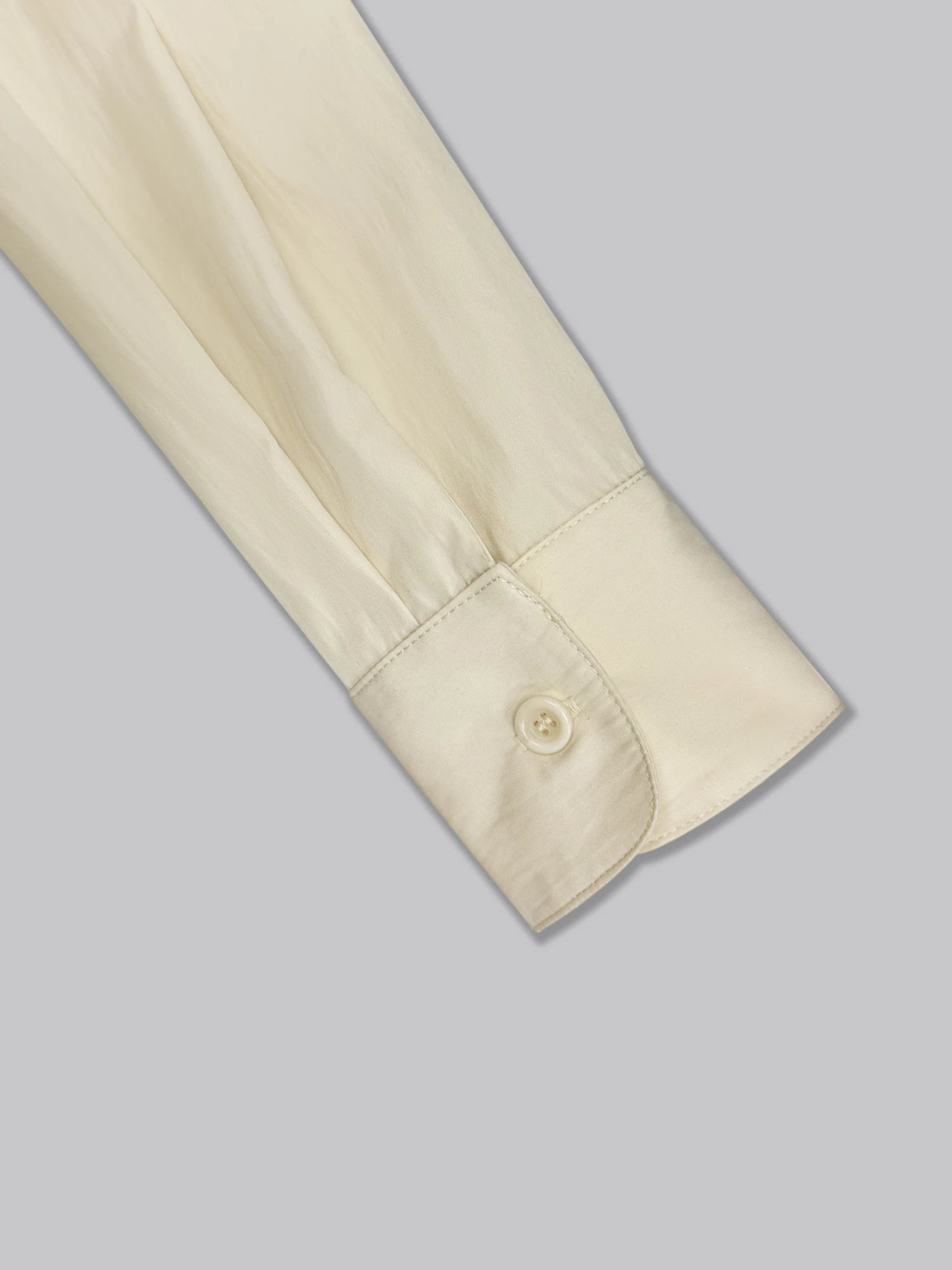 Détail du poignet boutonné de la robe chemise écrue